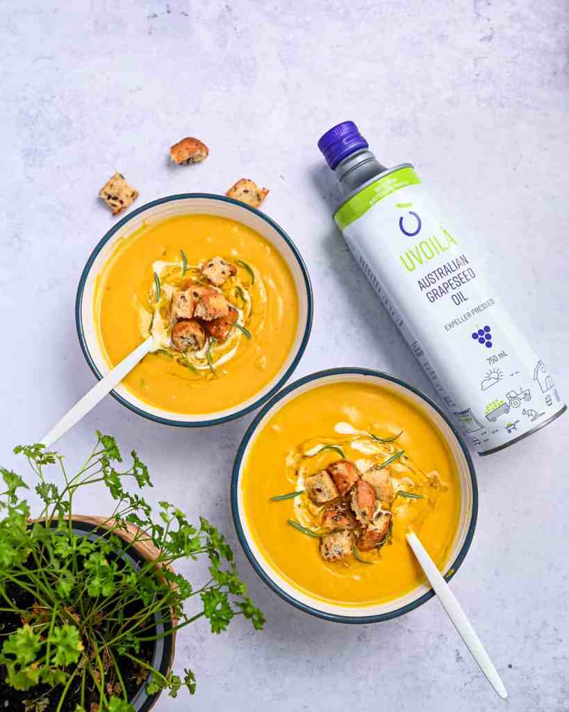 Two bowls of pumpkin soup with Uvoila grapeseed oil bottle